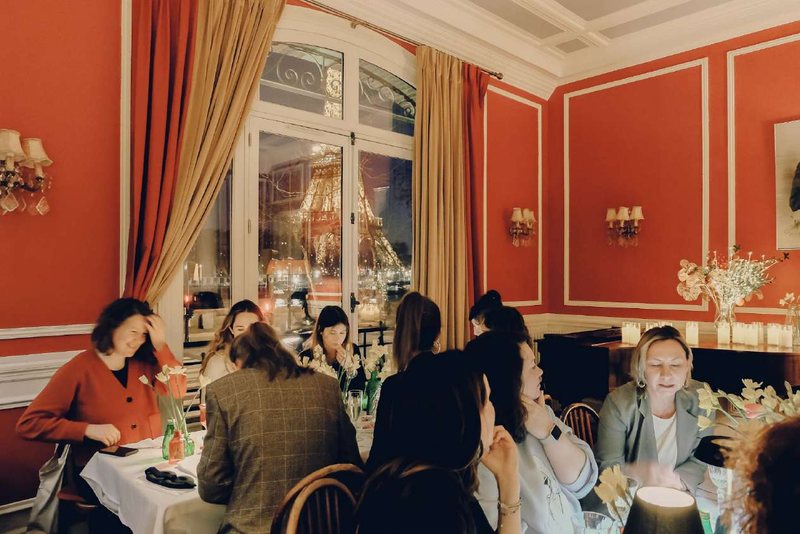 Evening gathering with the Eiffel Tower illuminated through the window